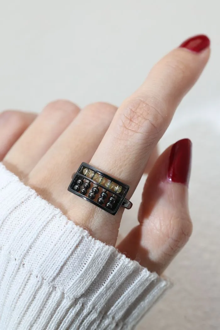 A model wearing the Golden Beads Abacus Ring in black gold