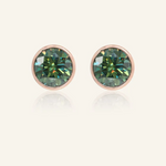 A pair of elegant earrings, each featuring a one carat green moissanite stone set in a bezel rose gold setting.