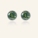 A pair of elegant earrings, each featuring a one carat green moissanite stone set in a bezel silver setting.