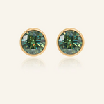 A pair of elegant earrings, each featuring a one carat green moissanite stone set in a bezel yellow gold setting.