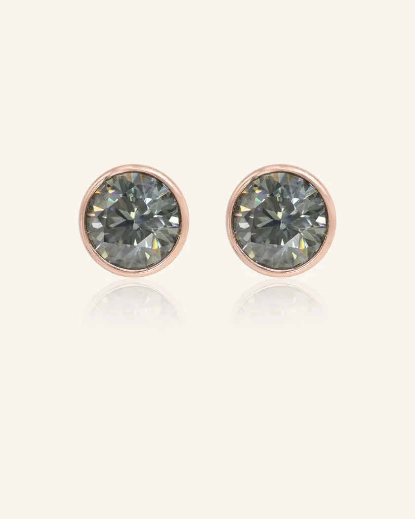 Modern and minimalistic one-carat gunmetal grey moissanite bezel studs set in rose gold, exuding understated elegance with a sleek metallic sparkle.