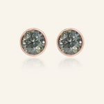 Modern and minimalistic one-carat gunmetal grey moissanite bezel studs set in rose gold, exuding understated elegance with a sleek metallic sparkle.