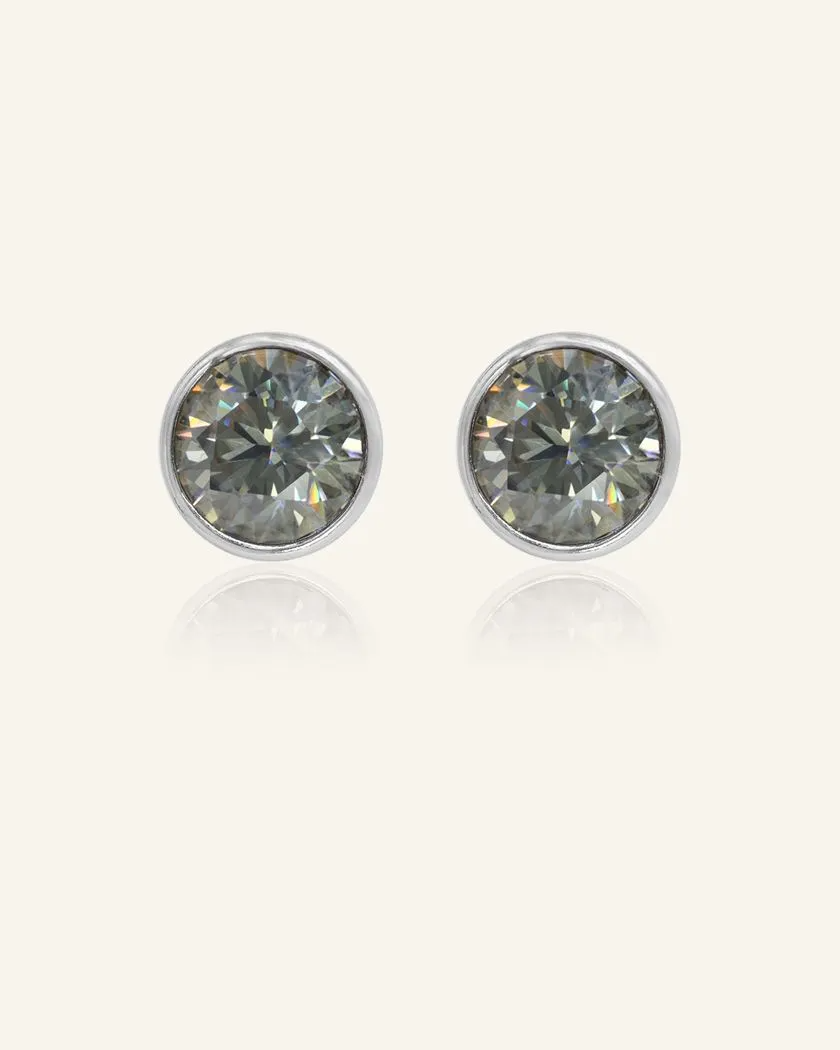 Modern and minimalistic one-carat gunmetal grey moissanite bezel studs set in silver, exuding understated elegance with a sleek metallic sparkle.