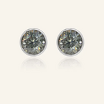 Modern and minimalistic one-carat gunmetal grey moissanite bezel studs set in silver, exuding understated elegance with a sleek metallic sparkle.