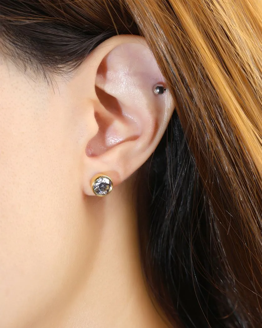 A model wearing the Modern and minimalistic one-carat gunmetal grey moissanite bezel studs set in yellow gold, exuding understated elegance with a sleek metallic sparkle.