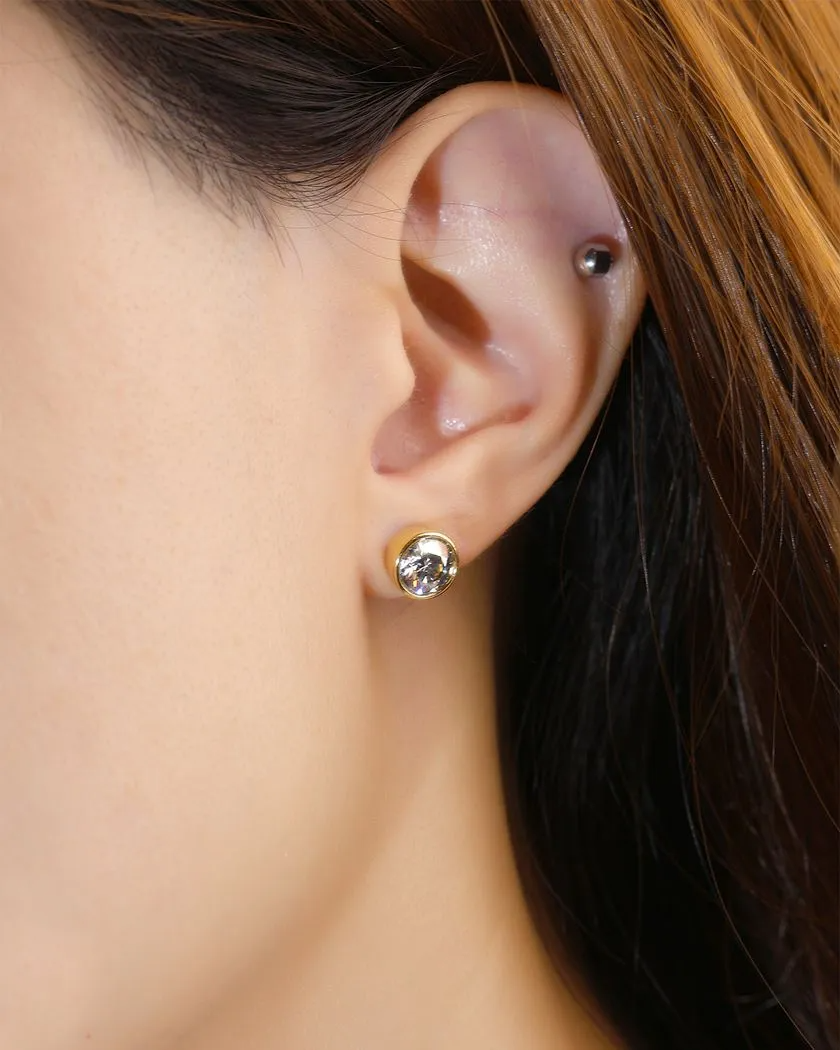 A model wearing the Modern and minimalistic one-carat gunmetal grey moissanite bezel studs set in yellow gold, exuding understated elegance with a sleek metallic sparkle.
