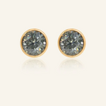 Modern and minimalistic one-carat gunmetal grey moissanite bezel studs set in yellow gold, exuding understated elegance with a sleek metallic sparkle.