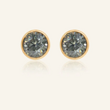 Modern and minimalistic one-carat gunmetal grey moissanite bezel studs set in yellow gold, exuding understated elegance with a sleek metallic sparkle.
