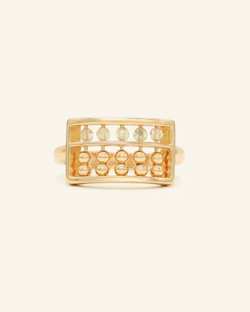 A yellow gold abacus ring featuring a rectangular frame with golden beads and yellow citrine stones, designed to mimic a traditional abacus, adding a playful and unique touch to your jewelry collection.