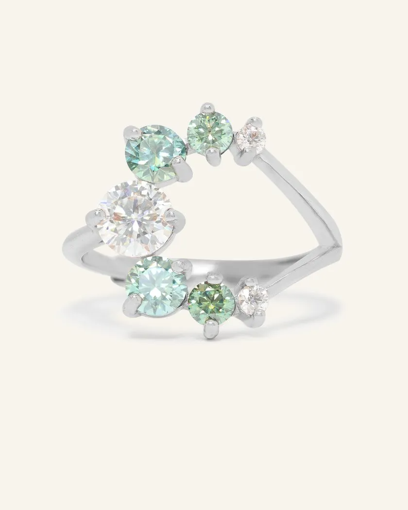 Elegant silver moissanite ring featuring a central large moissanite stone surrounded by smaller green moissanite stones in a unique crescent design