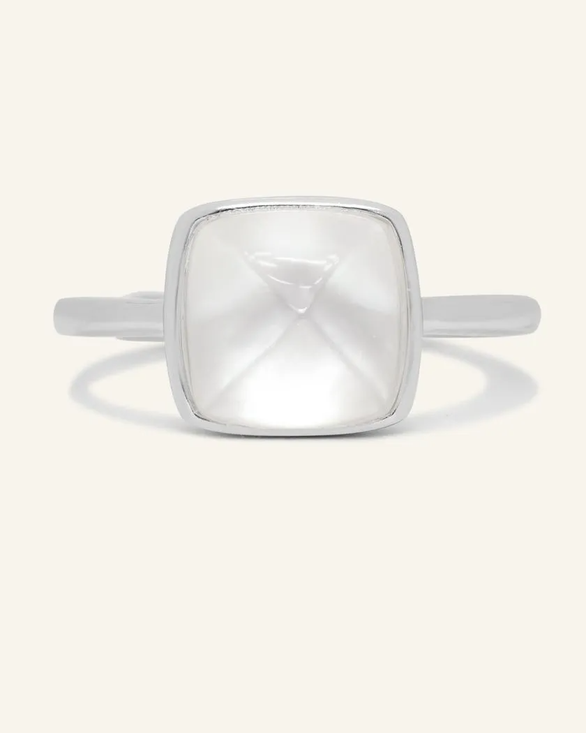 A silver ring featuring a large, faceted clear quartz stone cut in a sugarloaf shape, set in a simple, square bezel setting.