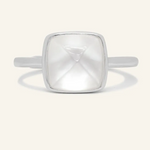 A silver ring featuring a large, faceted clear quartz stone cut in a sugarloaf shape, set in a simple, square bezel setting.