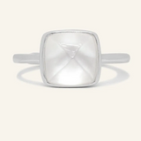 A silver ring featuring a large, faceted clear quartz stone cut in a sugarloaf shape, set in a simple, square bezel setting.