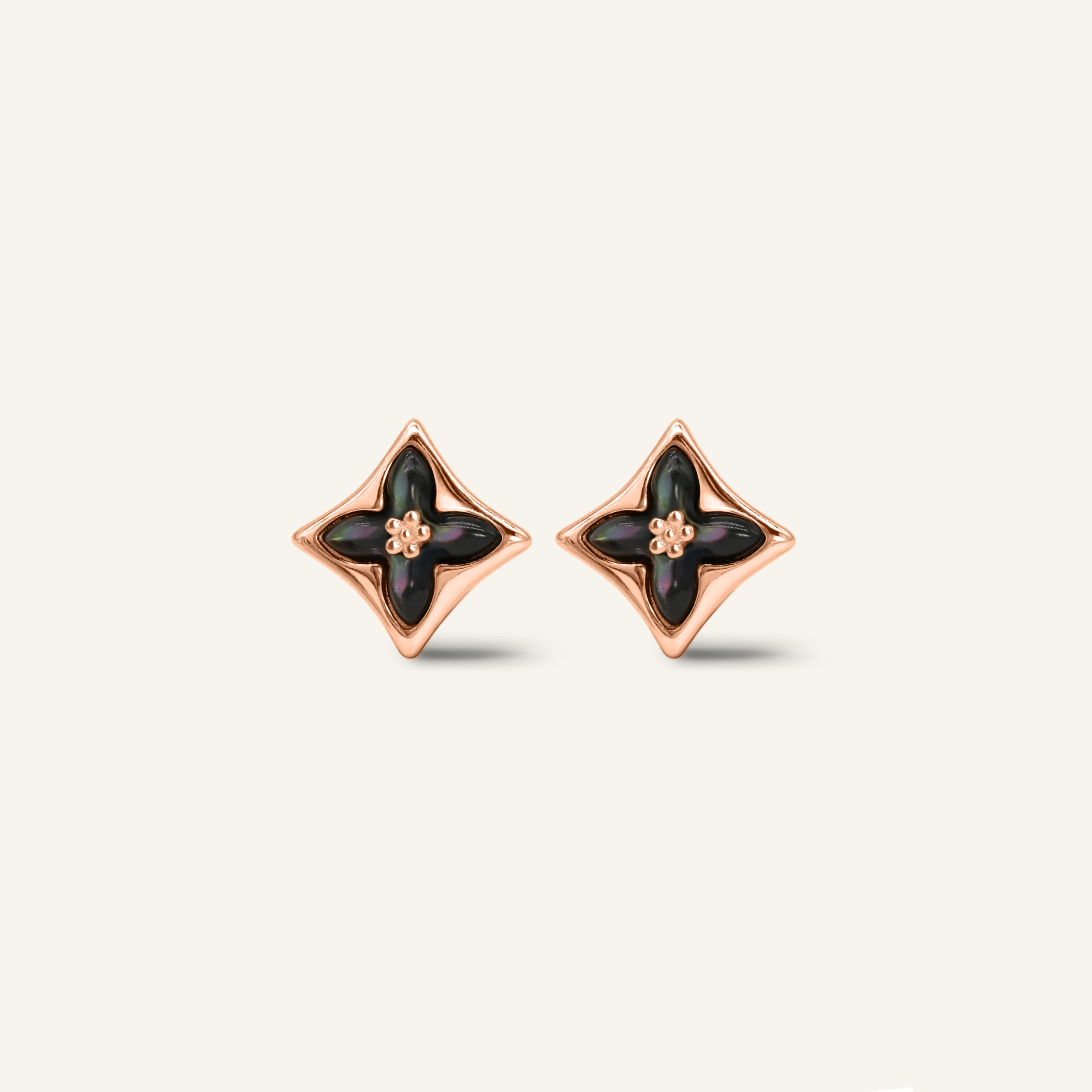 Close-up of a pair of rose gold clover monogram studs