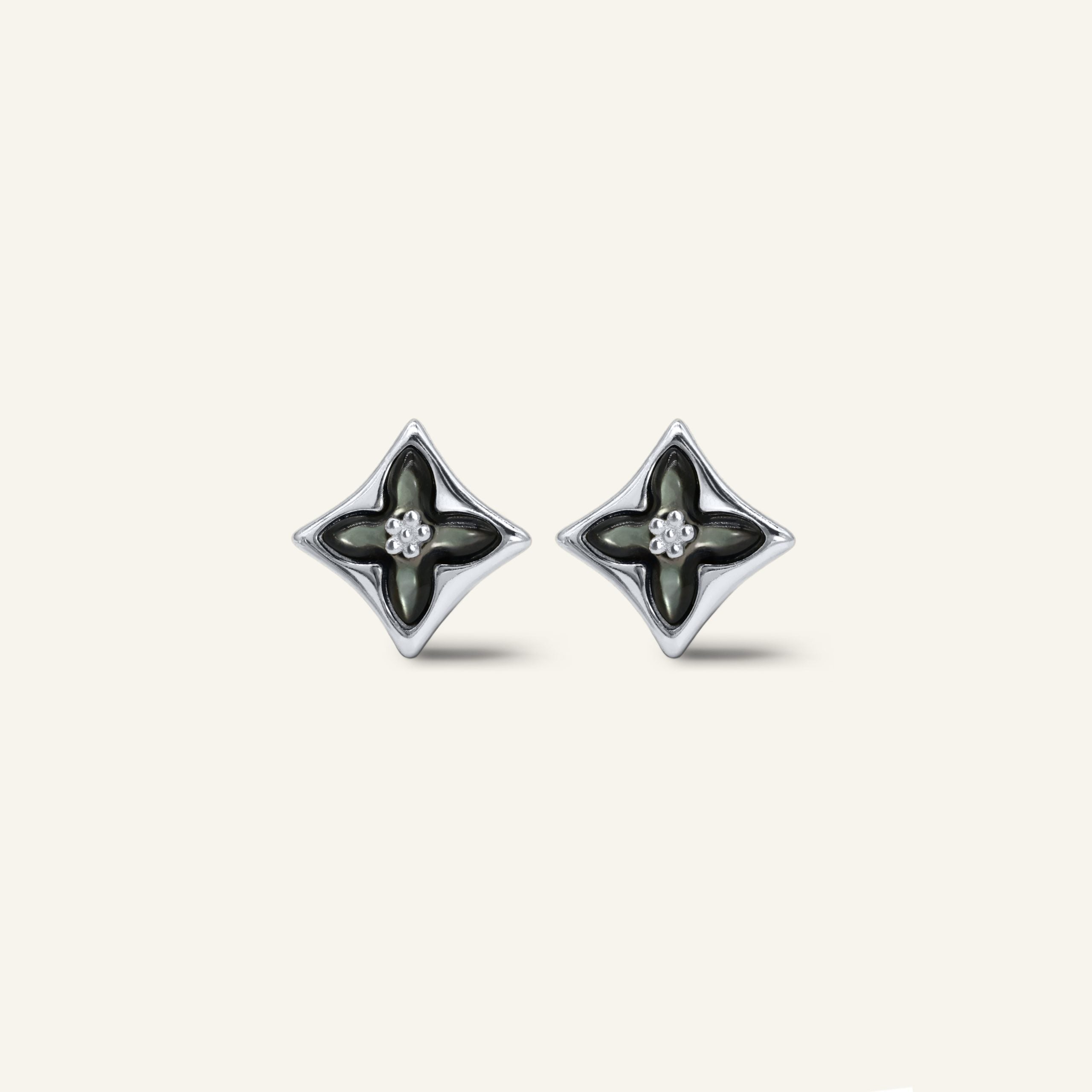 Close-up of a pair of silver clover monogram studs