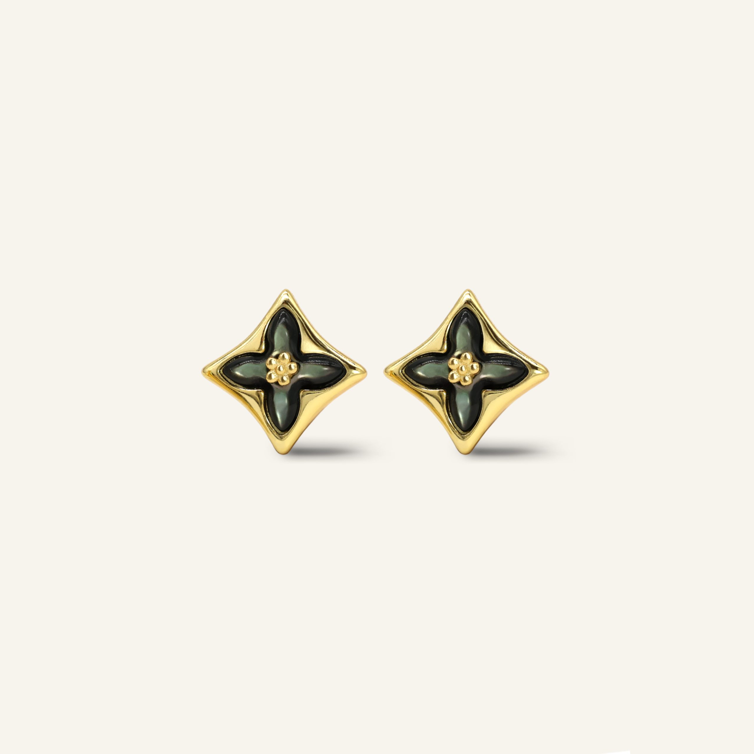 Close-up of a pair of yellow gold clover monogram studs