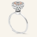 A silver ring with a rotating circular top that opens to reveal colorful gemstones inside, resembling a spinning hotpot.