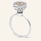 A silver ring with a rotating circular top that opens to reveal colorful gemstones inside, resembling a spinning hotpot.