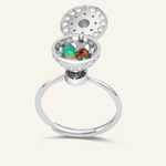 A silver ring with a rotating circular top that opens to reveal colorful gemstones inside, resembling a spinning hotpot.