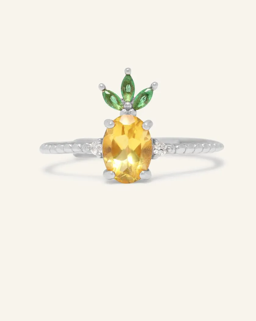 A pineapple-inspired citrine ring featuring a vibrant oval-cut yellow citrine as the centerpiece, accented with green marquise cubic zirconia as leaves and set on a delicate silver band.