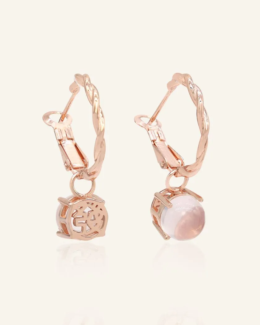 A pair of elegant rose gold hoop earrings, each featuring a dangling rose quartz stone.
