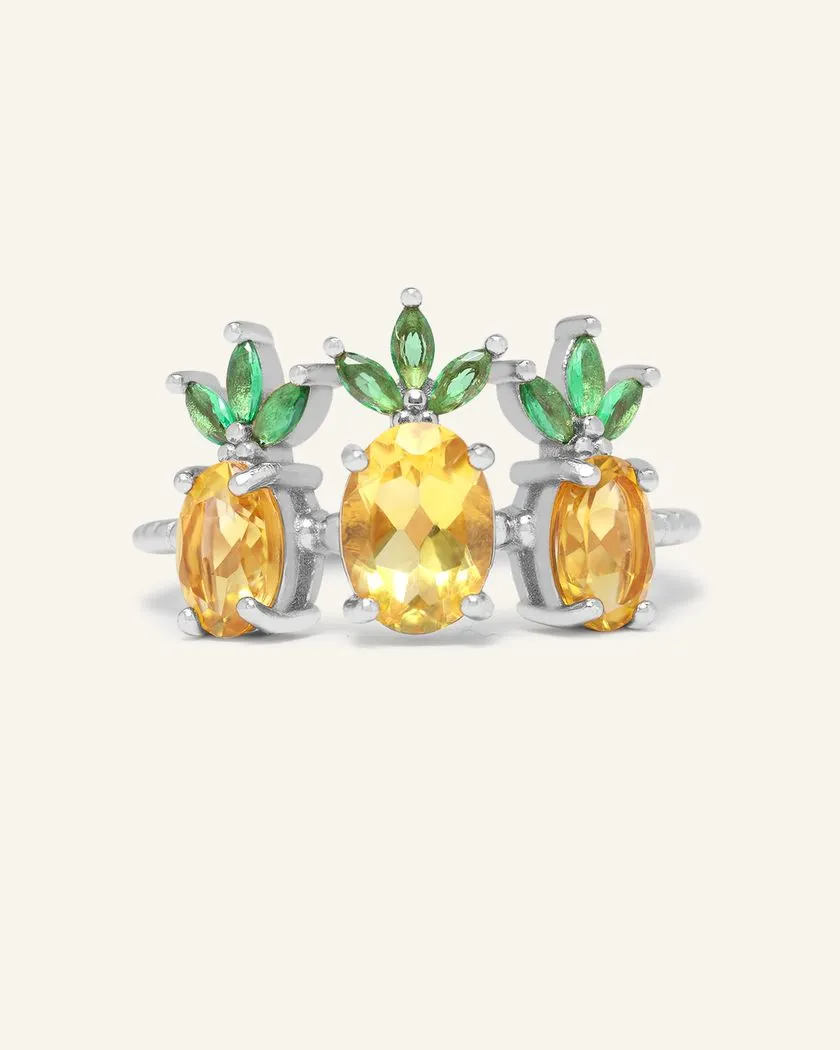 A trio of pineapple-themed rings featuring yellow citrine gemstones mimicking the fruit's body, with green cubic zirconia leaves at the top, all set in a silver band.