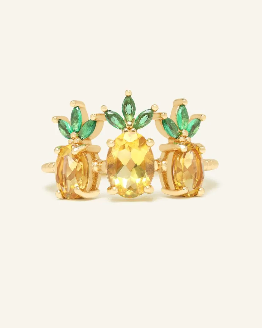 A trio of pineapple-themed rings featuring yellow citrine gemstones mimicking the fruit's body, with green cubic zirconia leaves at the top, all set in a yellow gold band.
